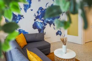 a living room with a couch and a world map on the wall at 7Seas City-Apartment Kaiserslautern - Balkon l NETFLIX l 24h Self Check-in in Kaiserslautern