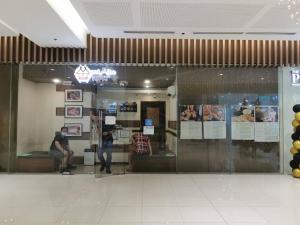 a man sitting on a couch in a store window at Love@Grace Residences near BGC. in Manila