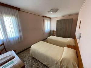 um quarto de hotel com duas camas e uma janela em Casa Caburlotto em Veneza