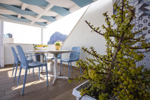 a patio with a table and chairs and a plant at Acquarò Suite in San Vito lo Capo