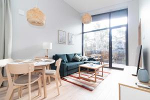 ein Wohnzimmer mit Tisch und Couch in der Unterkunft Vanagupes Park Apartments, By Cohost in Palanga