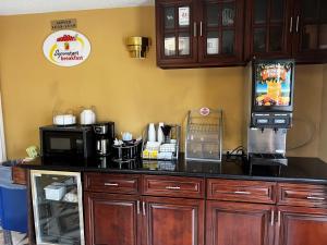 a kitchen with a counter with microwaves and appliances at Super 8 by Wyndham Houston West Katy in Katy