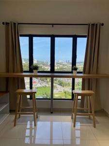 a room with two stools and a large window at Traders garden c180 in Cheras