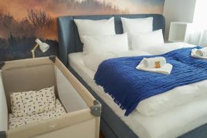 a bedroom with two twin beds with a blue blanket at 7Seas City-Apartment Kaiserslautern - Balkon l NETFLIX l 24h Self Check-in in Kaiserslautern