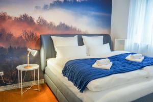 a bedroom with a bed with a painting on the wall at 7Seas City-Apartment Kaiserslautern - Balkon l NETFLIX l 24h Self Check-in in Kaiserslautern