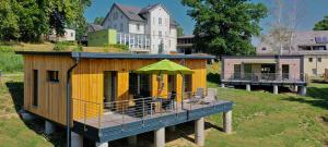 a house with a deck with a green umbrella at Das Logierhaus in Bad Alexandersbad