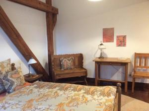 クサンテンにあるFerienwohnung Haumannshofのベッドルーム1室(ベッド1台、椅子、テーブル付)