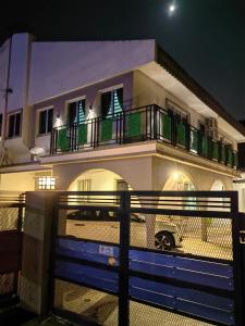 a building with a balcony with a car parked in front at Huge space for Friends & Families Gathering in Ipoh