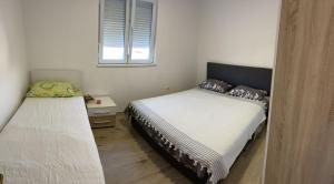 内乌姆Apartmani Žuti的有两张床和一扇窗户的卧室
