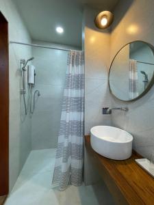 a bathroom with a sink and a mirror at Baan Jai Klang (บ้านใจกลาง) in Chiang Rai