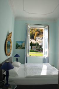 1 dormitorio con cama blanca y ventana en Residence Ville Lago Lugano, en Porto Ceresio