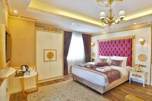a large bedroom with a large bed with a pink headboard at Emirhan Palace Hotel in Istanbul