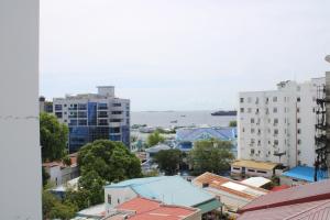 Blick auf eine Stadt mit Gebäuden und das Meer in der Unterkunft Beehive Central in Male City