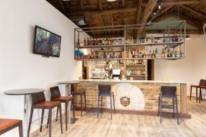 un bar en un restaurante con mesas y taburetes en Hotel Casa da Luz en Pastoriza