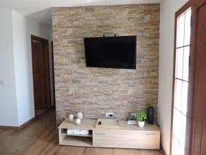a living room with a tv on a brick wall at Arbinfo Casa Rural in Guía de Isora