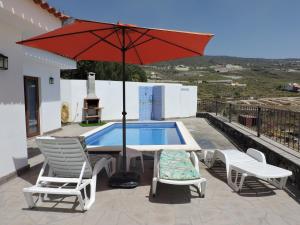 a patio with a table and chairs and an umbrella at Arbinfo Casa Rural in Guía de Isora