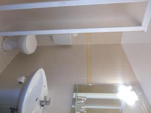 a bathroom with a white toilet and a sink at Residencial Santa Clara in Fátima