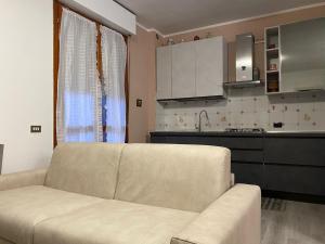 Una sala de estar con un sofá y una cocina. en Rho Fiera Apartment, en Rho