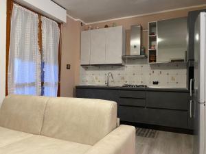 Una sala de estar con un sofá y una cocina. en Rho Fiera Apartment, en Rho