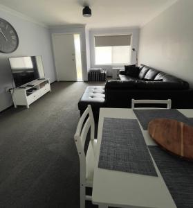 a living room with a black couch and a tv at Kulin Erindale Apartments in Kulin