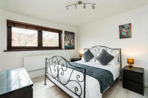 a bedroom with a black and white bed and two windows at Luxury Islington Apartment with Balcony Islington in London