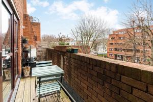 a wooden deck with a bench and a brick wall at Luxury Islington Apartment with Balcony Islington in London