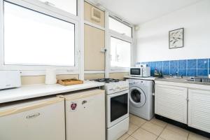a kitchen with a washing machine and a sink at A Skyhigh Stay for 2 in Vauxhall London in London