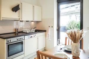 eine Küche mit weißen Schränken und einem Tisch mit einem Esszimmer in der Unterkunft Zentrales 7Seas Apartment Kaiserslautern - Balkon l 4 Pers l Self Check-in in Kaiserslautern
