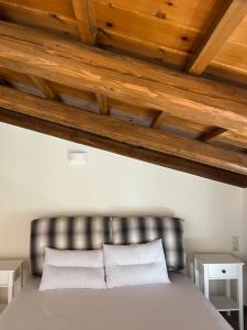 um quarto com uma cama de couro e duas mesas brancas em Cozy village house in Ano Asites em Áno Asítes