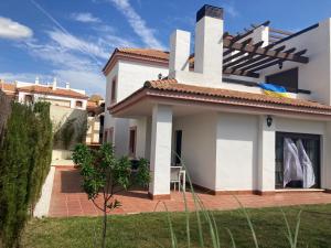 a white house with a patio and a yard at Chalet Hato Verde Golf in Guillena