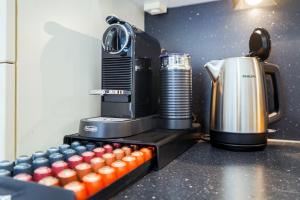 a coffee maker sitting on a counter next to a row of canisters at 7Seas City-Apartment Kaiserslautern - Balkon l NETFLIX l 24h Self Check-in in Kaiserslautern