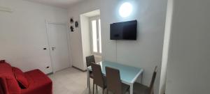 ein Wohnzimmer mit einem Tisch und einem roten Sofa in der Unterkunft Bilocale nel cuore di Sanremo in Sanremo