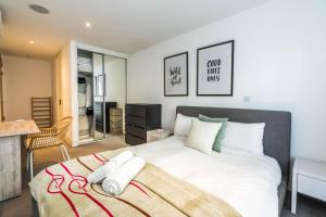 a bedroom with a large bed with white sheets at Apartment for 4 in the Heart of Shoreditch in London