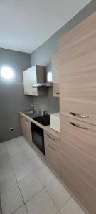 eine Küche mit Holzschränken und einem Waschbecken in der Unterkunft Bilocale nel cuore di Sanremo in Sanremo