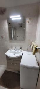 ein Badezimmer mit einem weißen Waschbecken und einem Spiegel in der Unterkunft Bilocale nel cuore di Sanremo in Sanremo