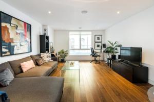 a living room with a couch and a flat screen tv at Apartment for 4 in the Heart of Shoreditch in London
