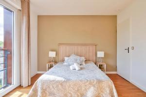a bedroom with a large bed with two lamps at OVELIA Chatou - Le Carré Brimont in Chatou +6 photos