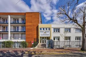 een appartementencomplex met een bord dat de versneller leest bij OVELIA Chatou - Le Carré Brimont in Chatou