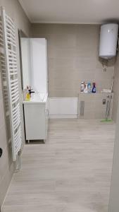 a kitchen with a white refrigerator and a sink at Grand Apartman in Živinice