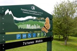 a sign with a butterfly on it in a park at Mabie House Hotel in Dumfries