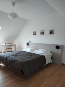 ein weißes Schlafzimmer mit einem Bett und einem Stuhl in der Unterkunft St Germain in Saint-Germain-du-Corbéis
