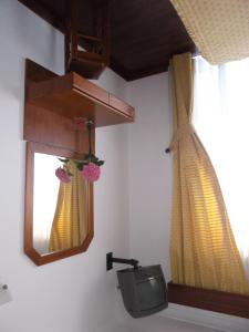 bagno con TV, specchio e finestra di Residencial Santa Clara a Fátima