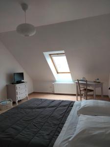 1 dormitorio con cama, escritorio y ventana en St Germain en Saint-Germain-du-Corbéis