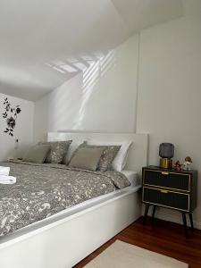 Habitación blanca con cama y mesita de noche en Tarino Apartment en Split