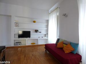 uma sala de estar com um sofá e uma televisão de ecrã plano em Innoi em Cagliari