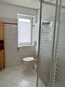 een badkamer met een toilet en een raam bij Haus Janus 3 - Wohnung 2 in Norderney