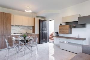 uma cozinha e sala de jantar com mesa e cadeiras em Lovely Flat with Balcony and Private Parking em Aci Castello