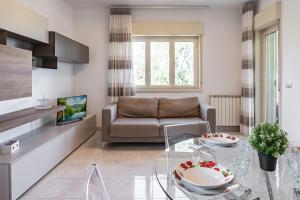 uma sala de estar com um sofá e uma mesa de vidro em Lovely Flat with Balcony and Private Parking em Aci Castello