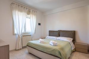 um quarto com uma cama com duas toalhas em Lovely Flat with Balcony and Private Parking em Aci Castello