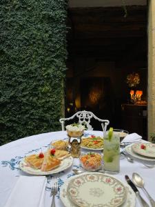 ein weißer Tisch mit Teller mit Lebensmitteln drauf in der Unterkunft Palazzo Albricci Peregrini in Como